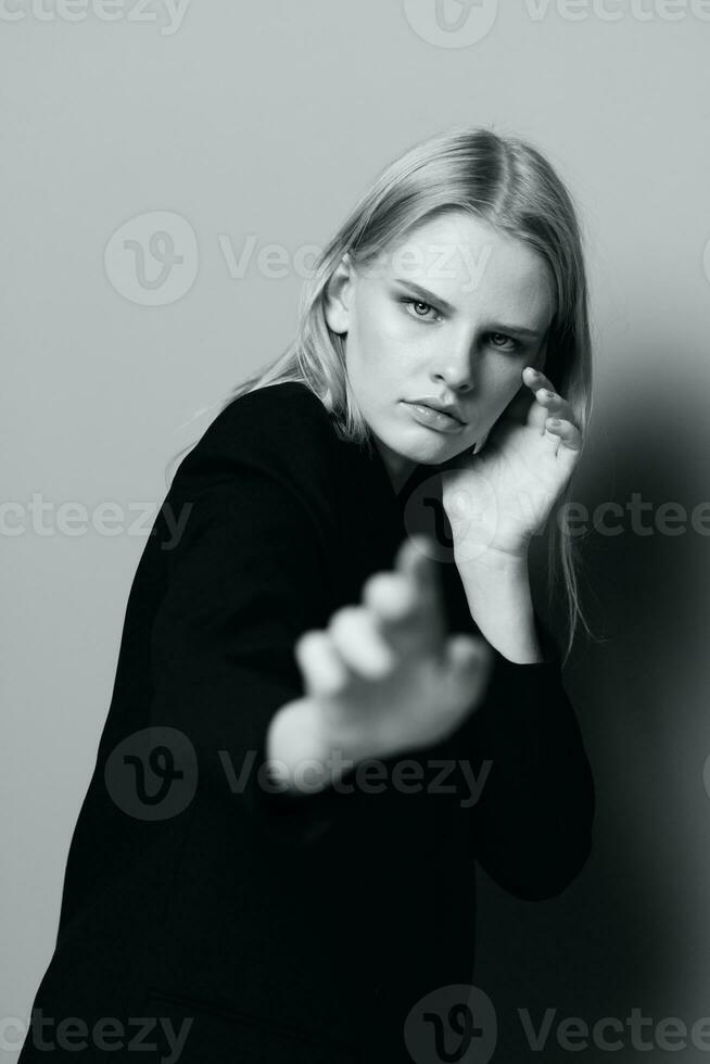 A young incredible blonde pulls her hands into the camera posing in the studio. Art fashion photography photo