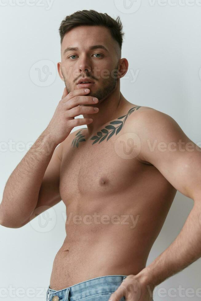 Sporty Sexy Muscular Handsome Naked Man holds hands on chin looks at camera posing isolated on over white studio background. Cool fashion offer. Model shoot for ad. Copy space photo