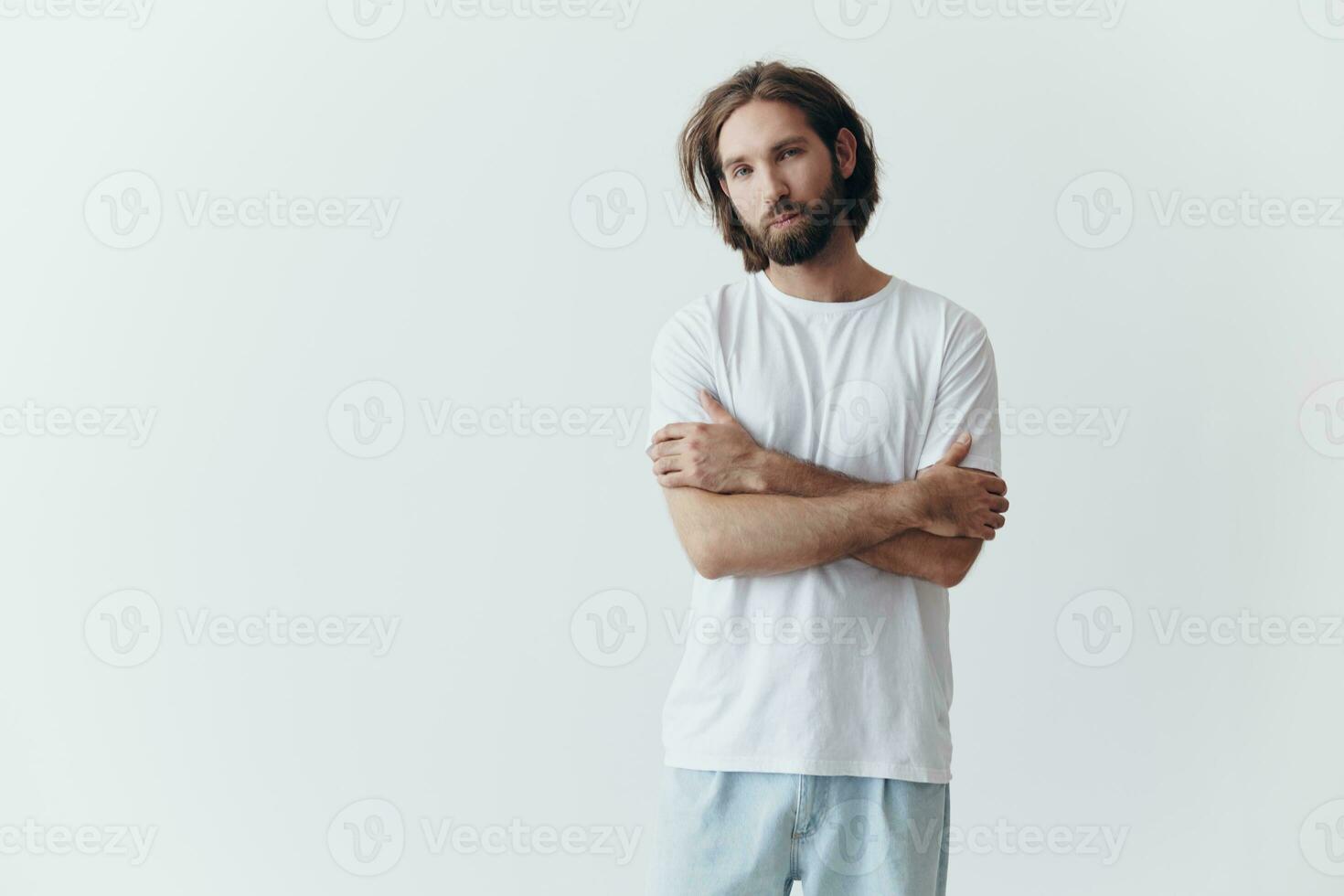 retrato de un triste hombre con un negro grueso barba y largo pelo en un blanco camiseta en un blanco aislado antecedentes foto