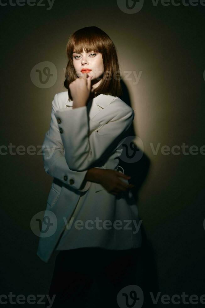 model in light coat gesticulate with hands studio photo