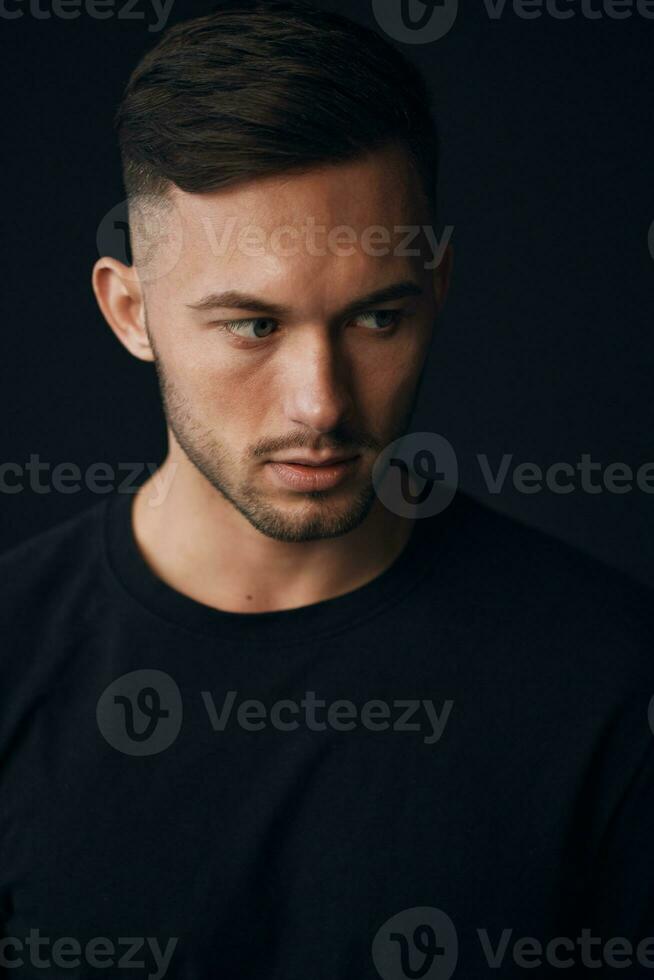 Modelling snapshots. Narcissistic self-confident tanned attractive handsome man in classic suit jacket looks aside posing isolated in over black studio background. Fashion offer. Copy space for ad photo