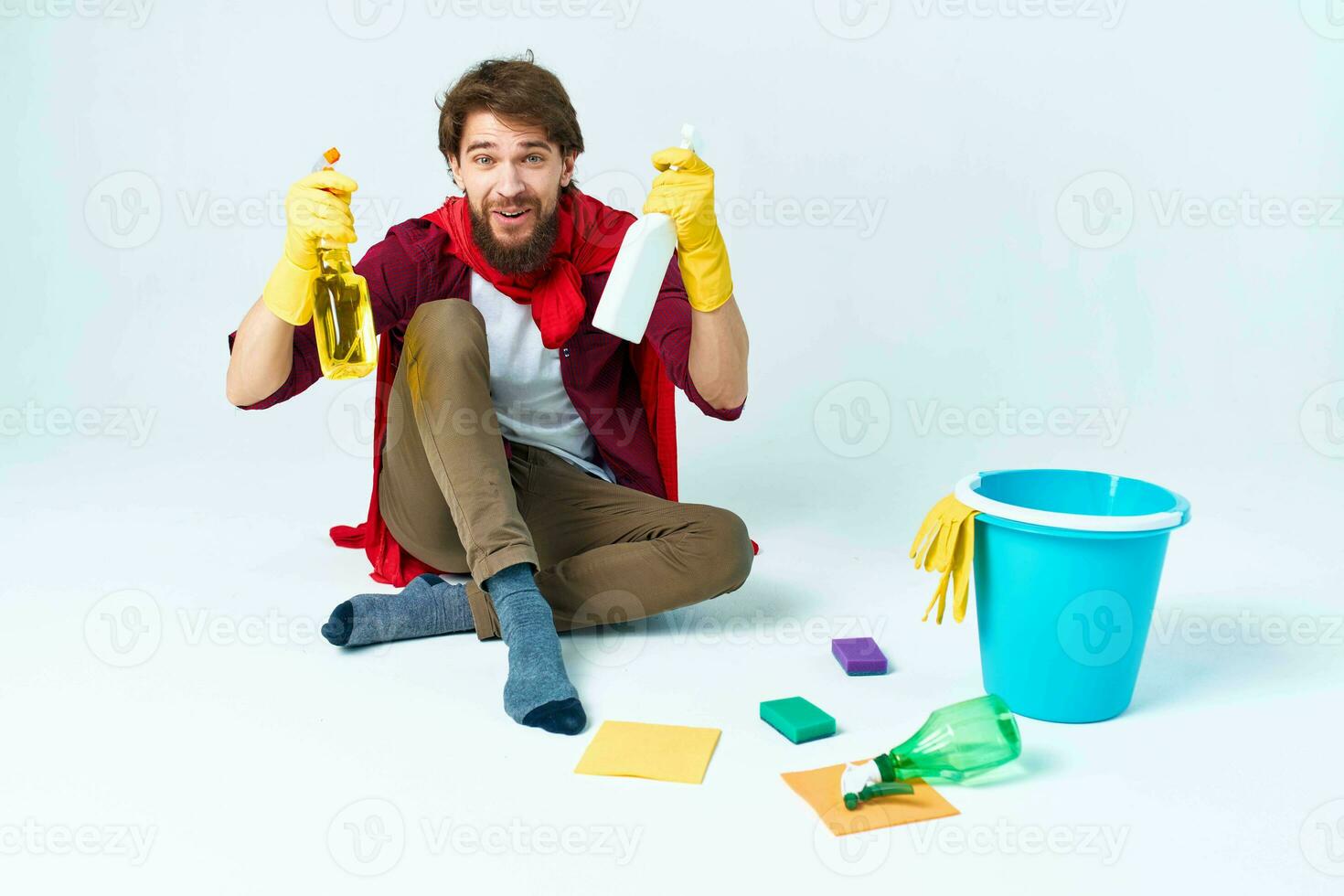 Man on the floor cleaning the house with cleaning supplies photo