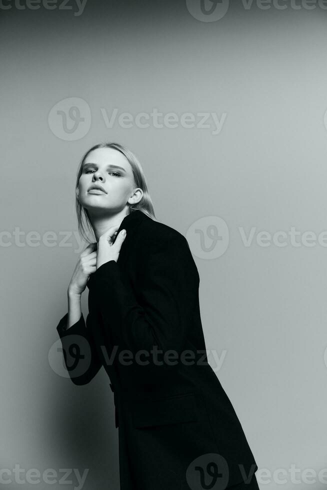 elegante niña toques su cuello posando en el estudio vestido en un clásico traje foto