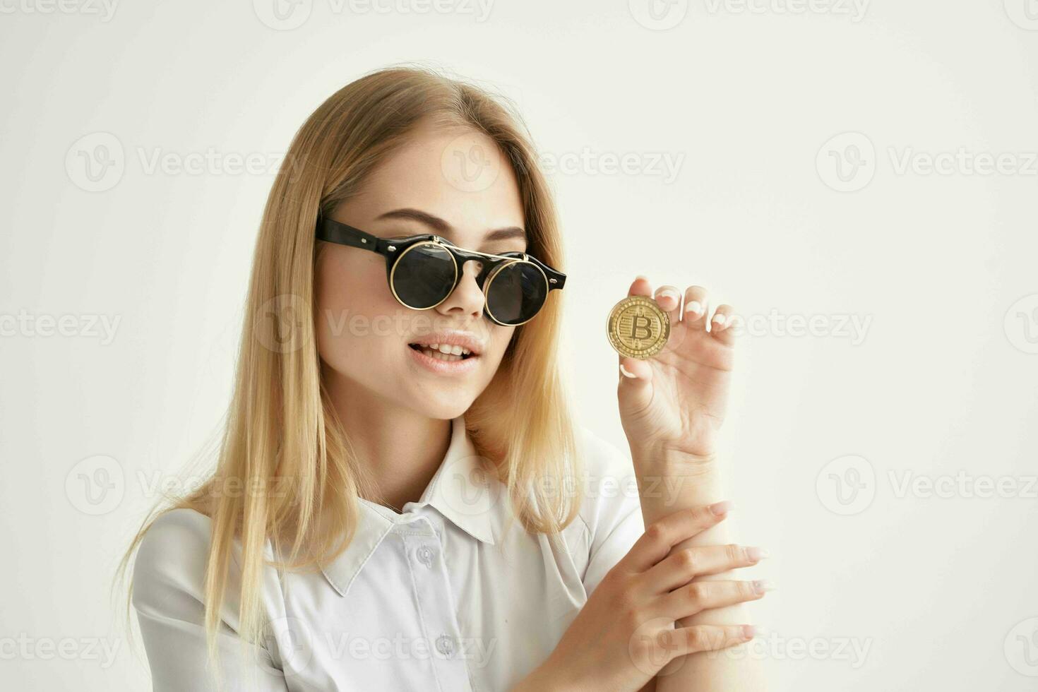 Businesswoman sunglasses Bitcoin cryptocurrency in hands isolated background photo