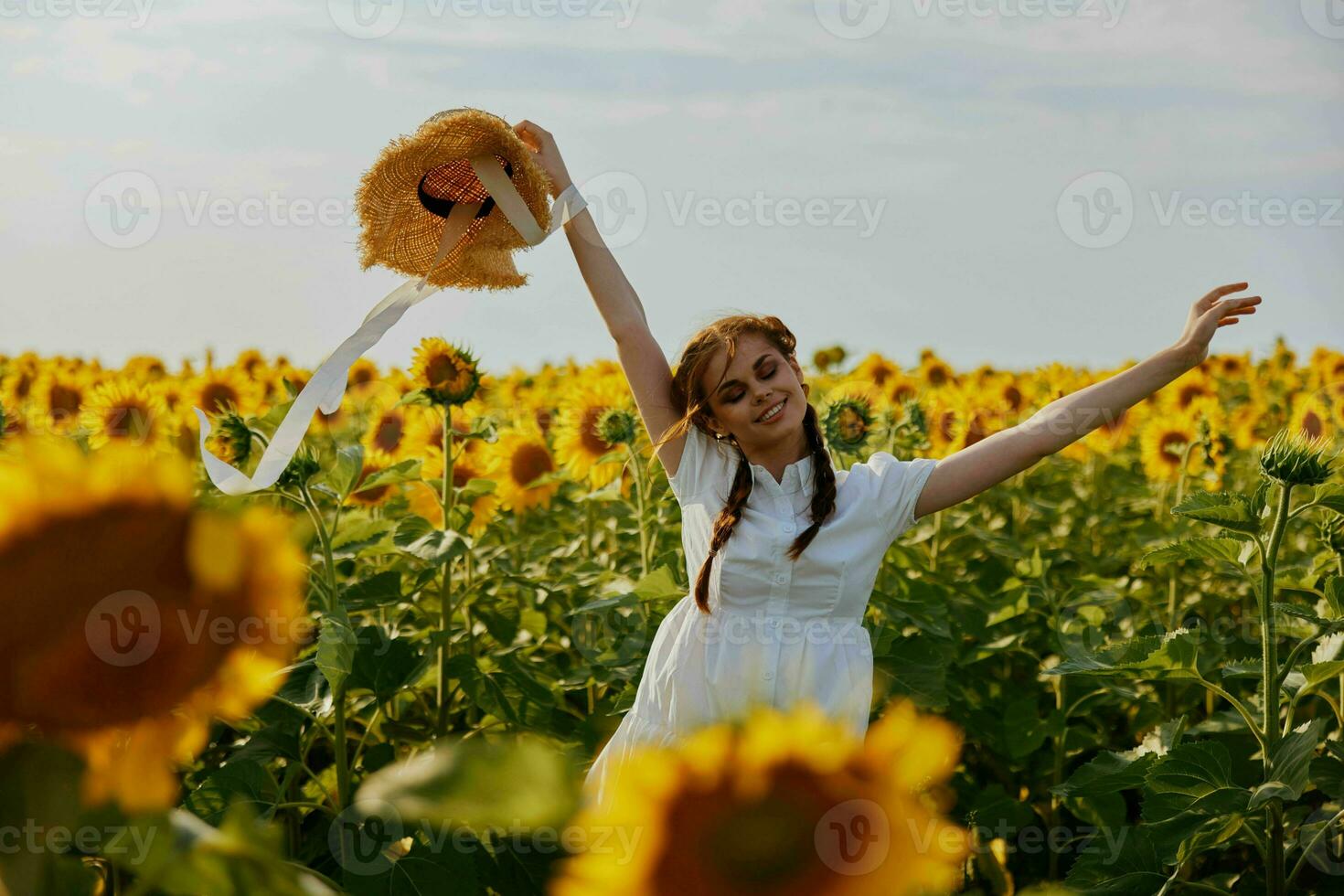 woman with pigtails In a field with blooming sunflowers unaltered photo