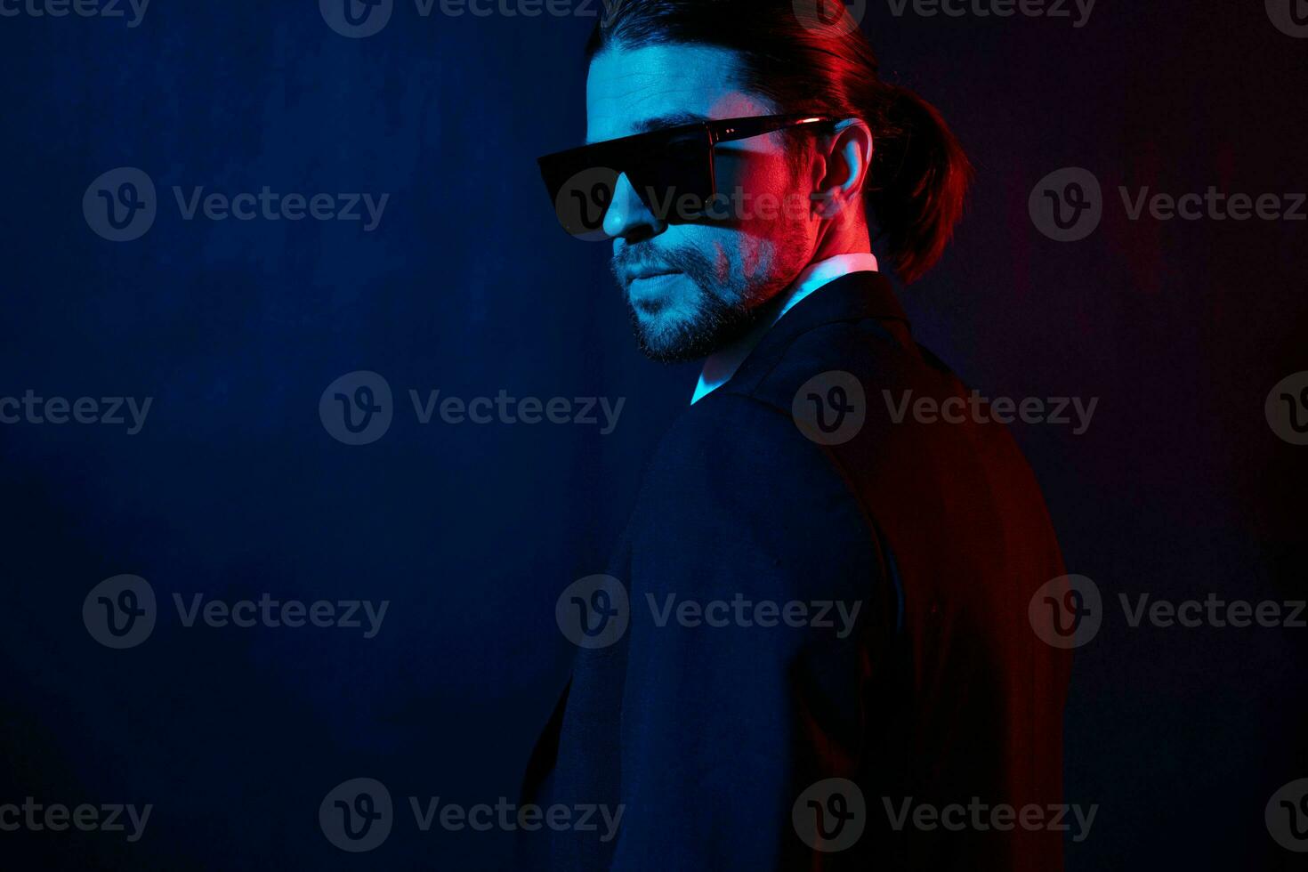 handsome man in a jacket posing self confidence sunglasses dark background photo