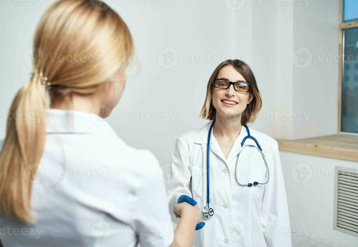 Doctor and patient near window in hospital interior photo