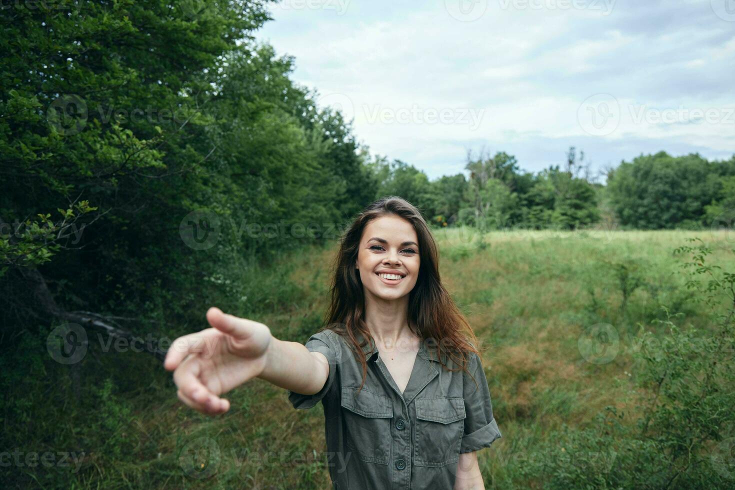 Woman in the field smile outstretched hands forward nature green trees photo