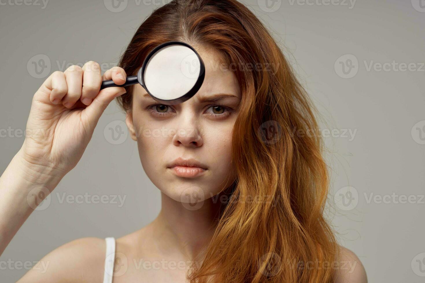 beautiful woman magnifier near the face hygiene close-up photo
