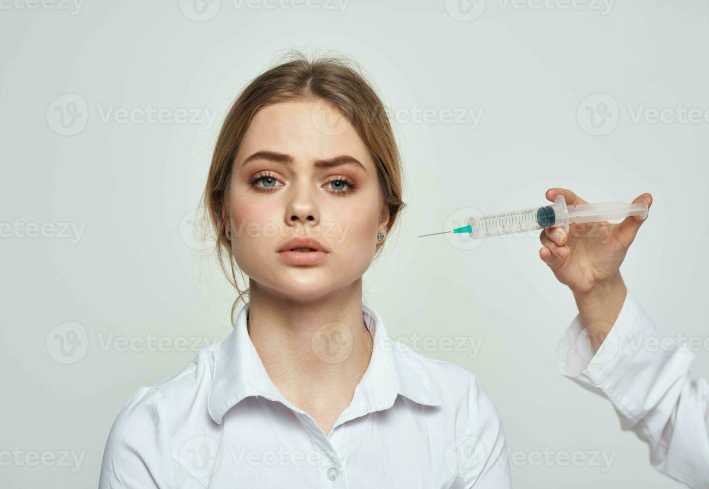 Syringe with liquid and a female patient in a white t-shirt health problems photo