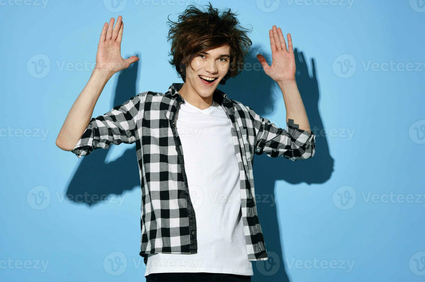 handsome young man with tousled hair plaid shirt posing photo