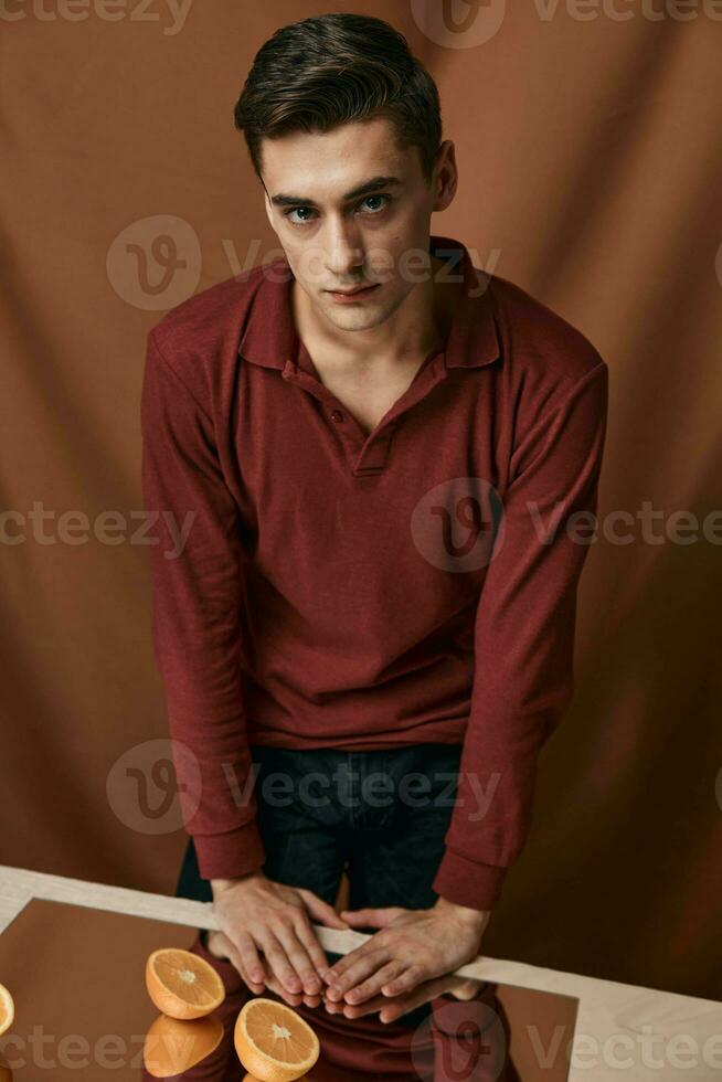 man in red shirt fashionable hairstyle close-up studio table with mirror photo