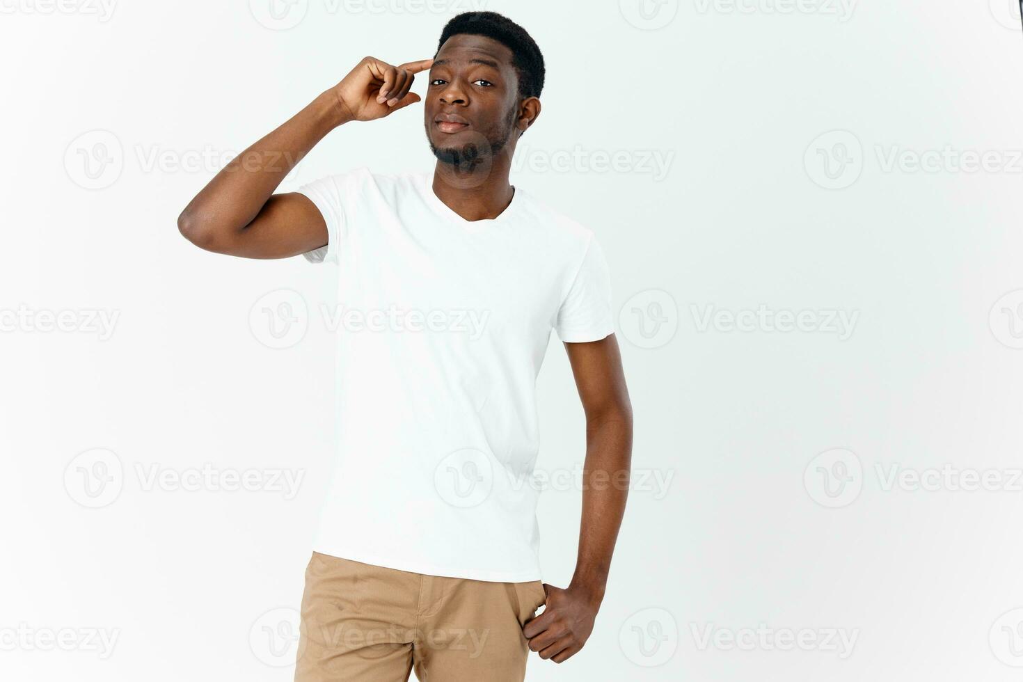 handsome guy of African appearance touches his head with his hands photo