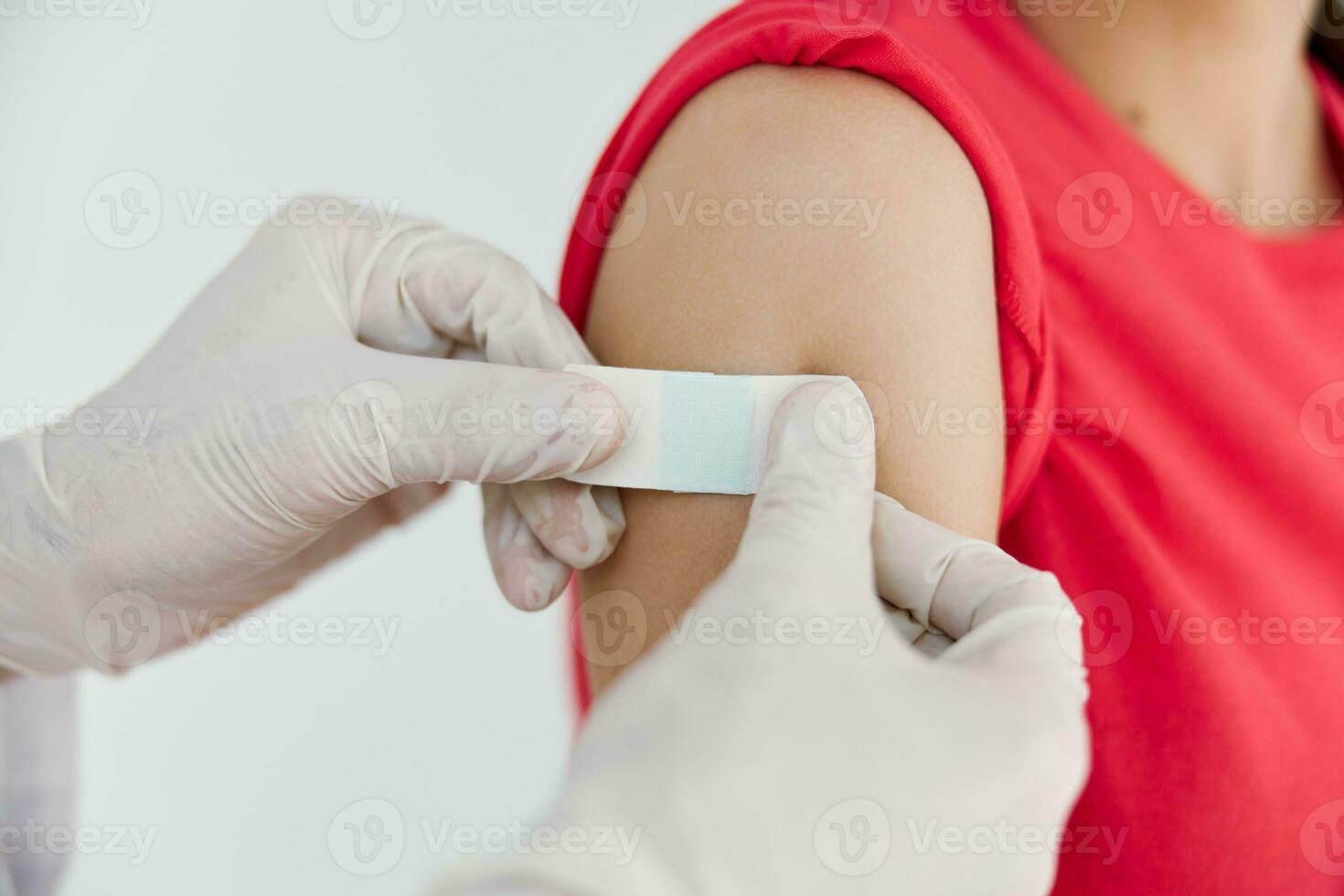 a doctor in medical gloves seals his hand with adhesive tape after injection close-ups photo