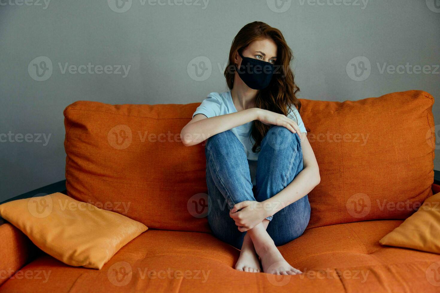 portrait of a woman in black protective masks sitting on the couch at home stay home concept photo