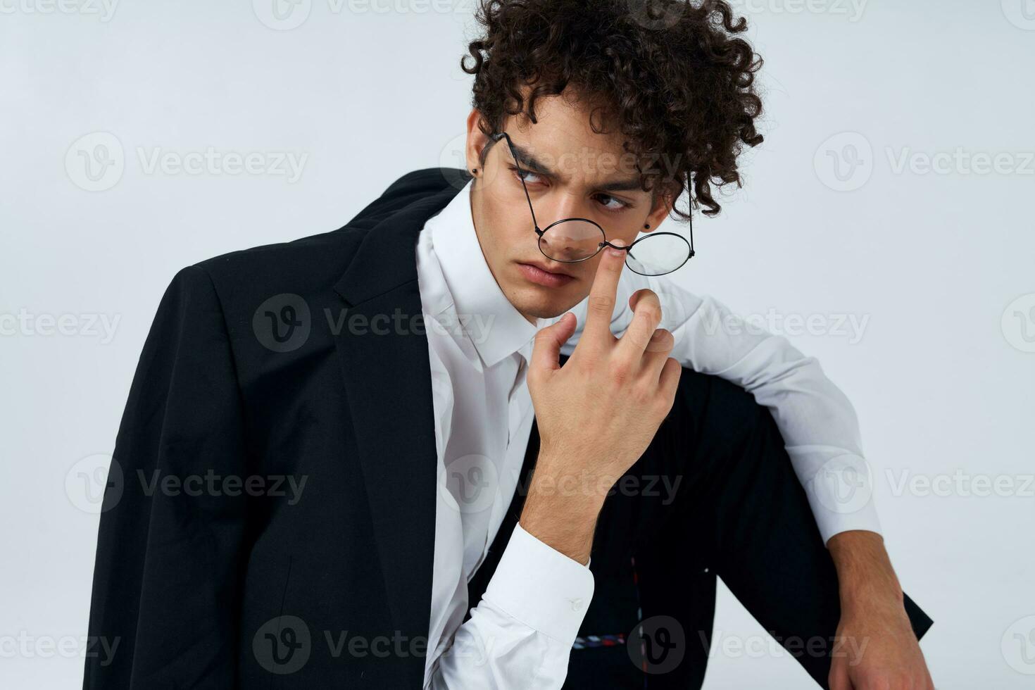 fashionable guy in classic suit and glasses sitting on the floor in a bright room cropped view photo