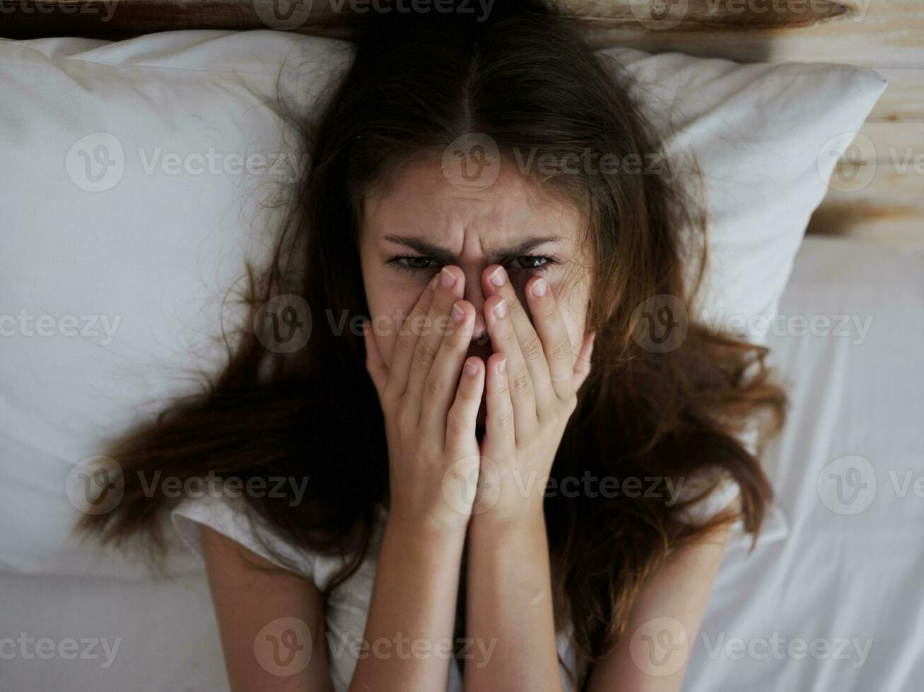 crying woman lying in bed temperature upset photo