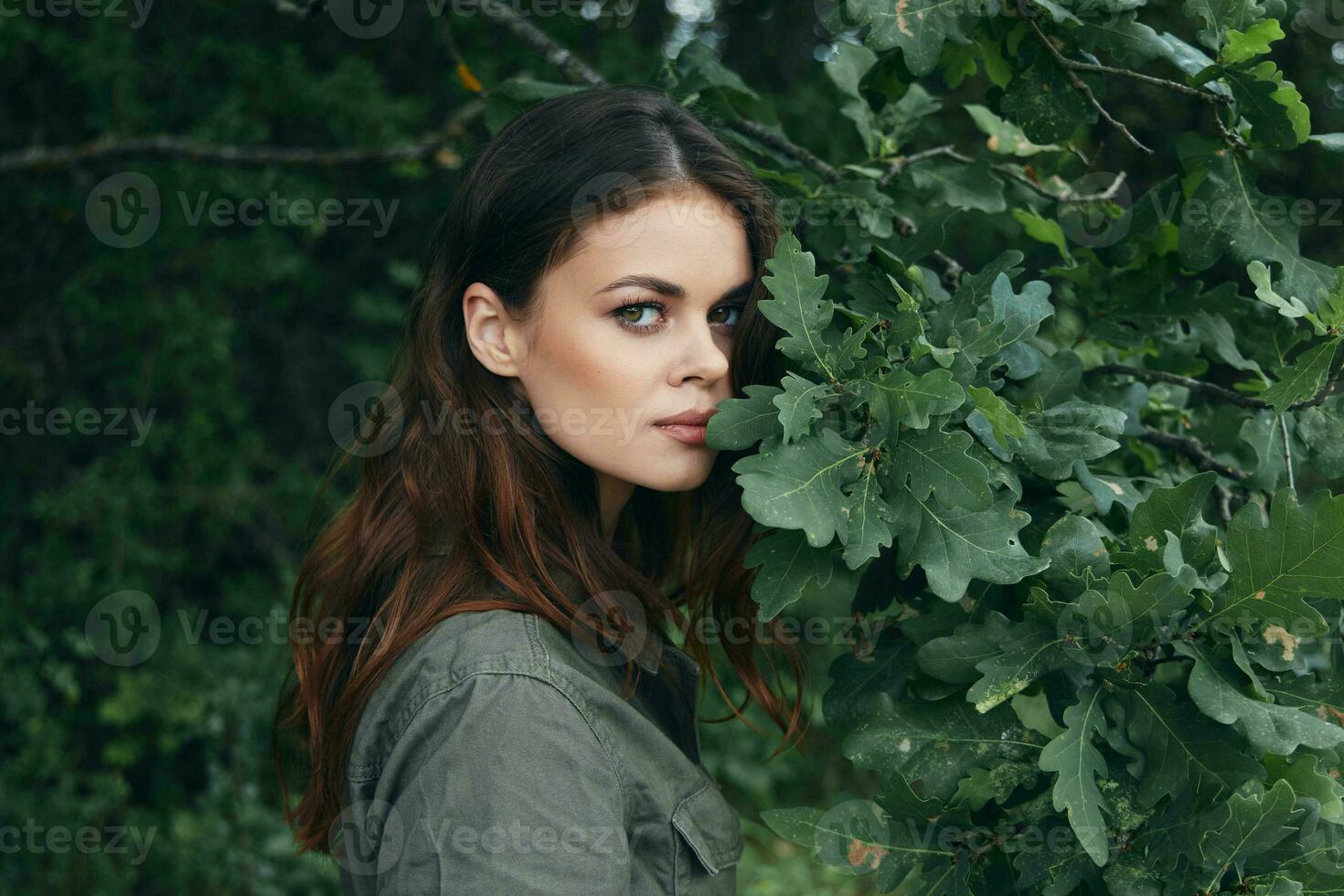 Woman in the forest Green leaves shrub look ahead nature photo