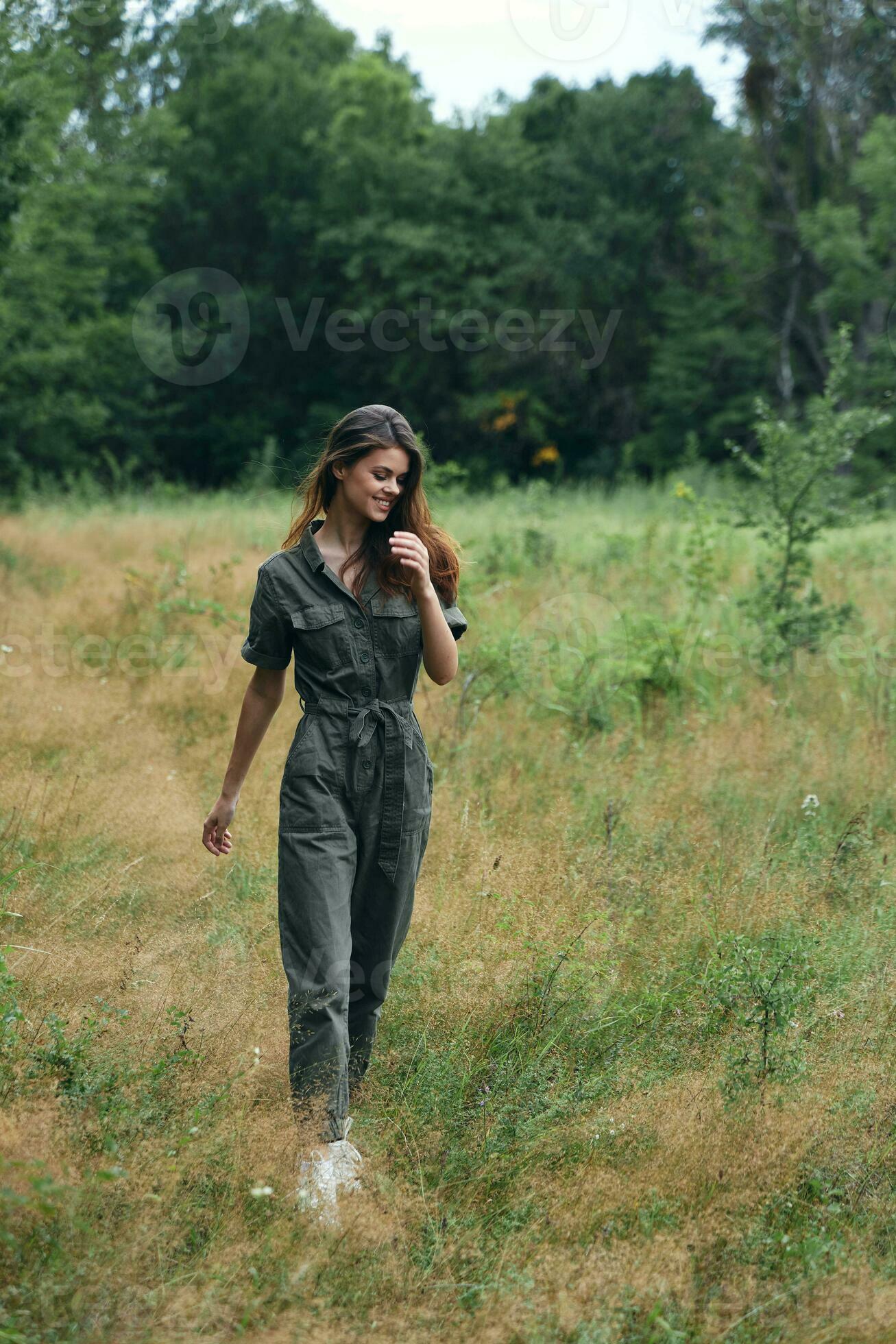 Woman in the forest walking through the field red hair green suit