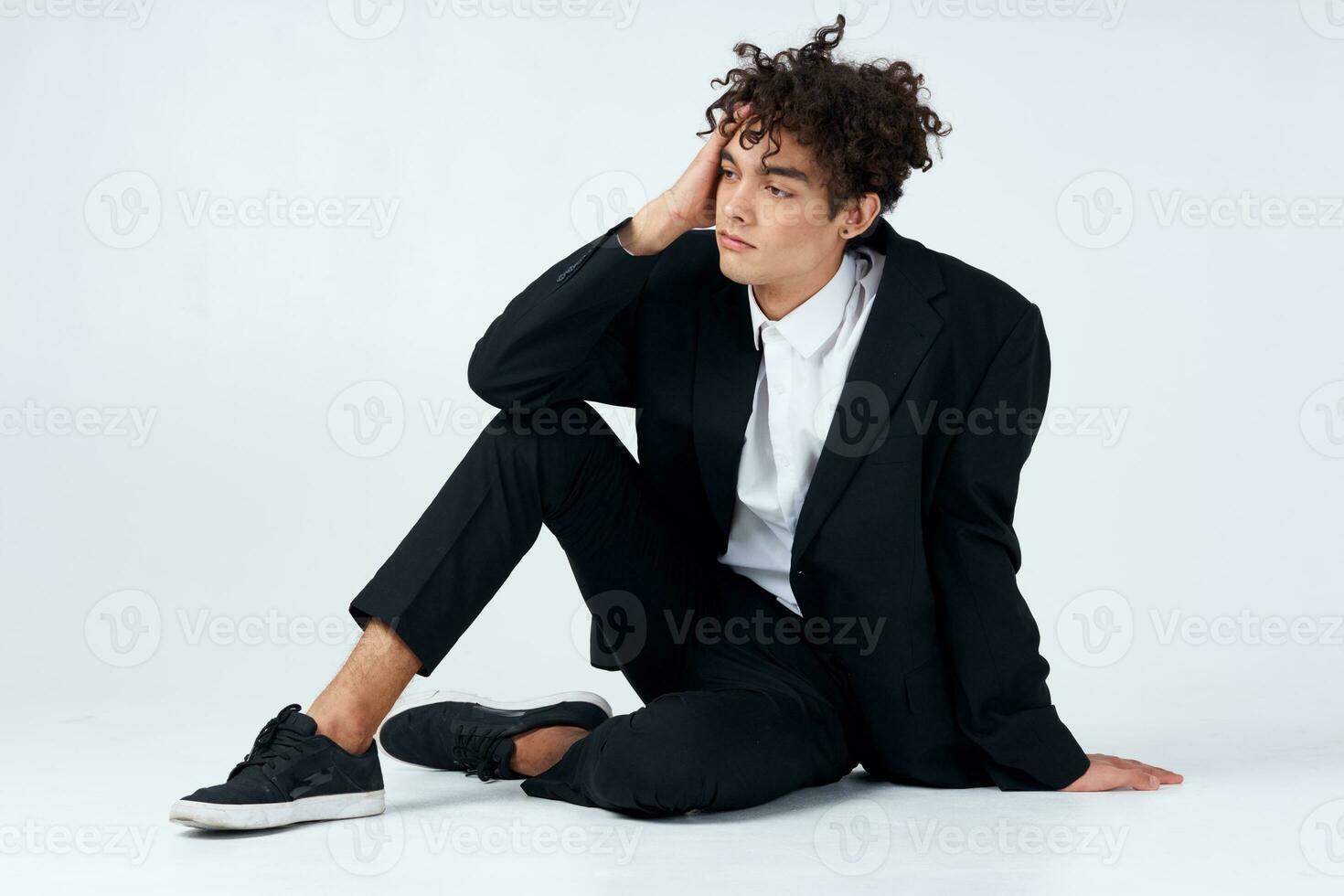 business man in suit curly hair light background studio fun photo