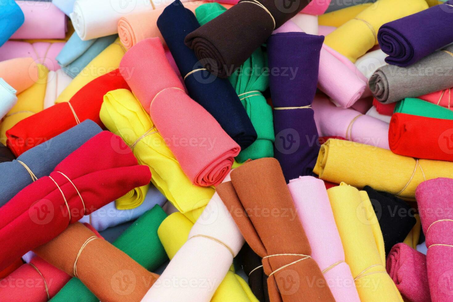 Detailed close up view on samples of cloth and fabrics in different colors found at a fabrics market photo