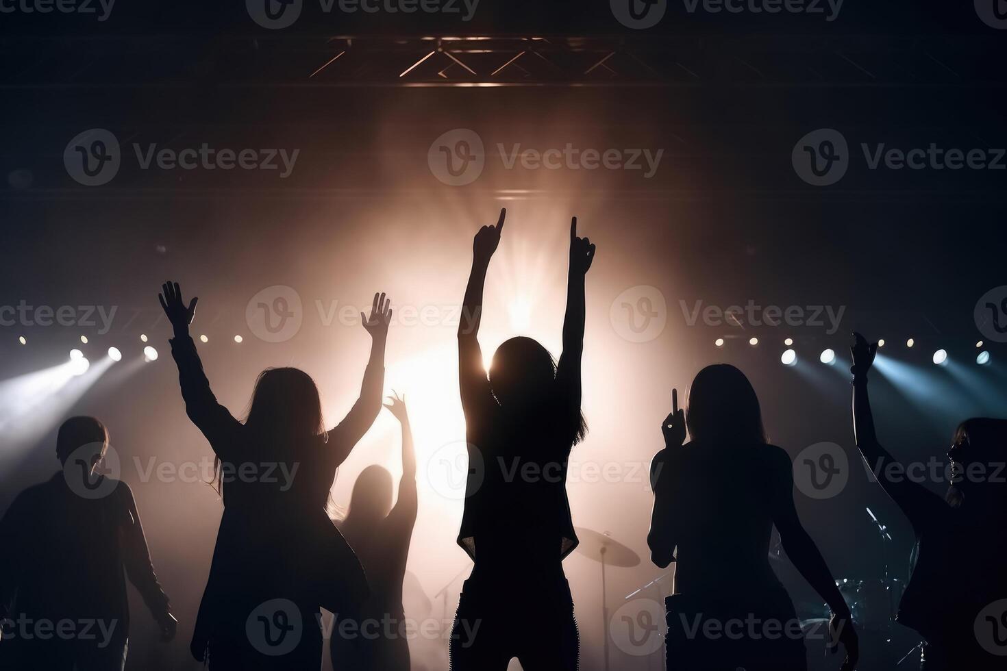 Black silhouette of a huge crowd of cheering people in front of a rock stage with soft bokeh lights created with technology. photo