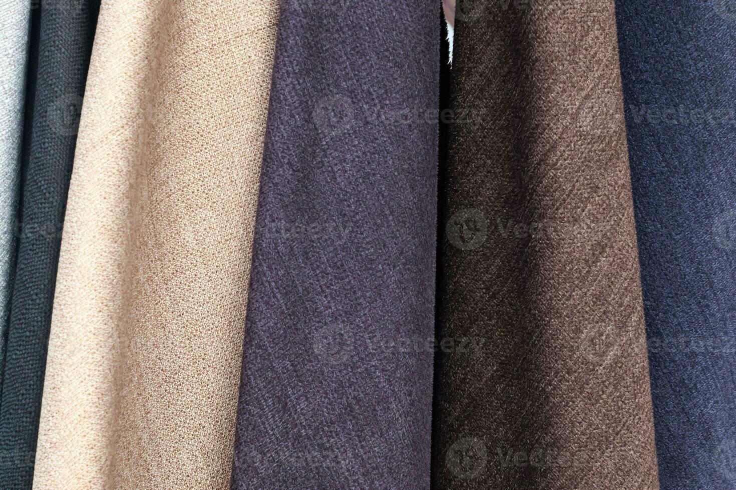 Detailed close up view on samples of cloth and fabrics in different colors found at a fabrics market photo