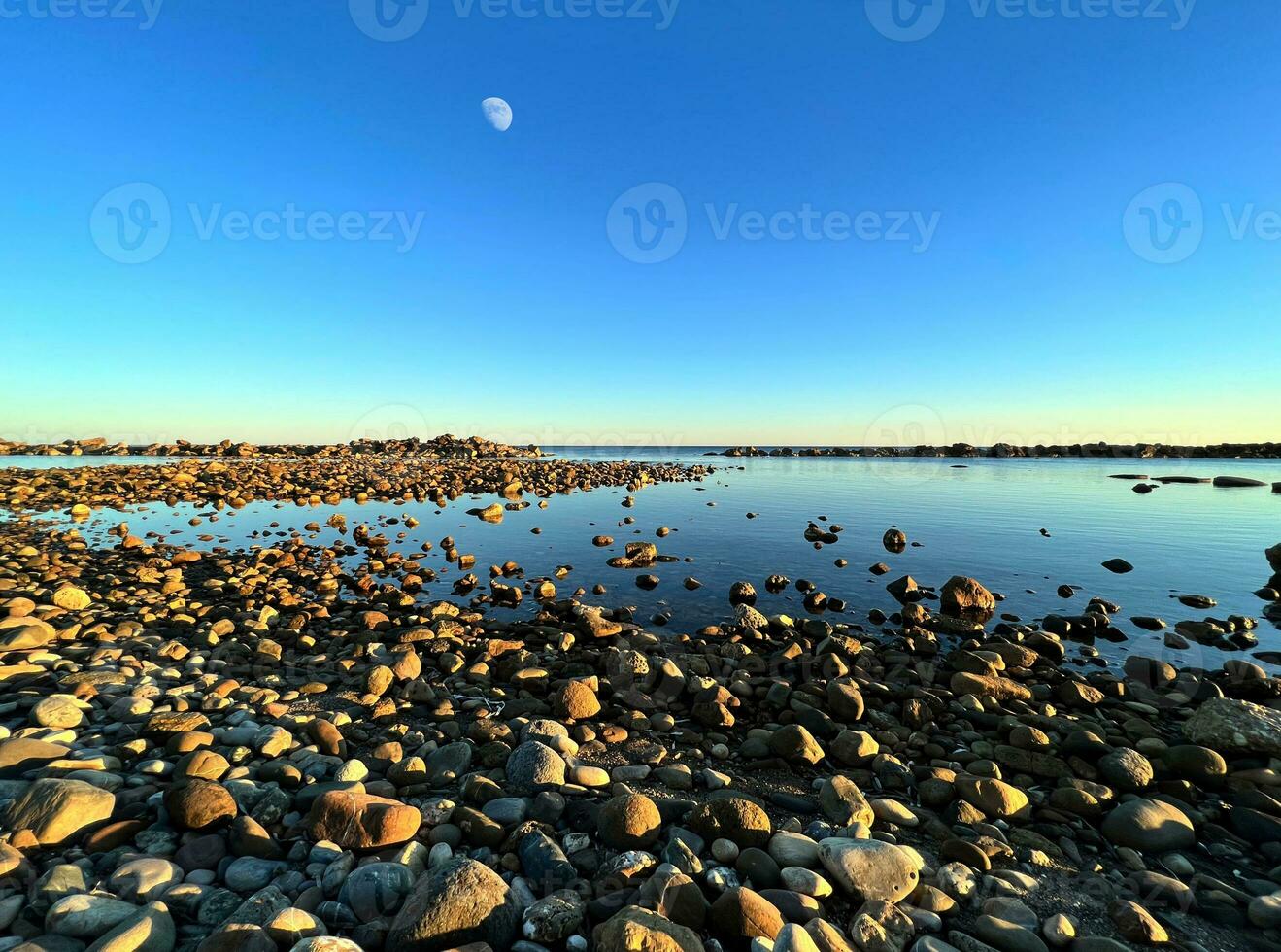 Rocky shore with calm sea at twilight photo