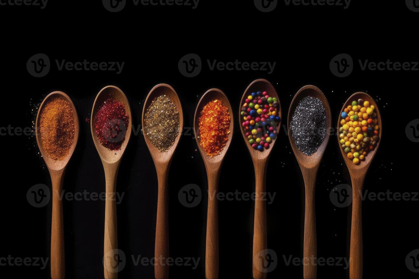 A row of wooden spoons filled with different types of spices on black background. photo