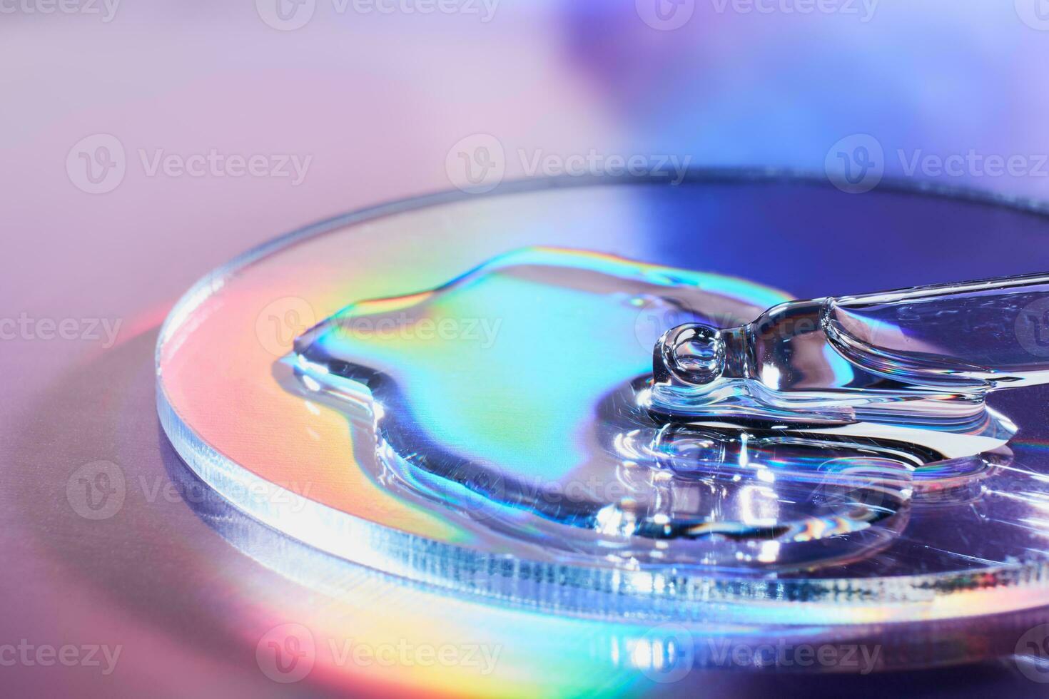 Pipette with sample of cosmetic product in petri dish on holographic background, iridescent highlights, selective focus photo