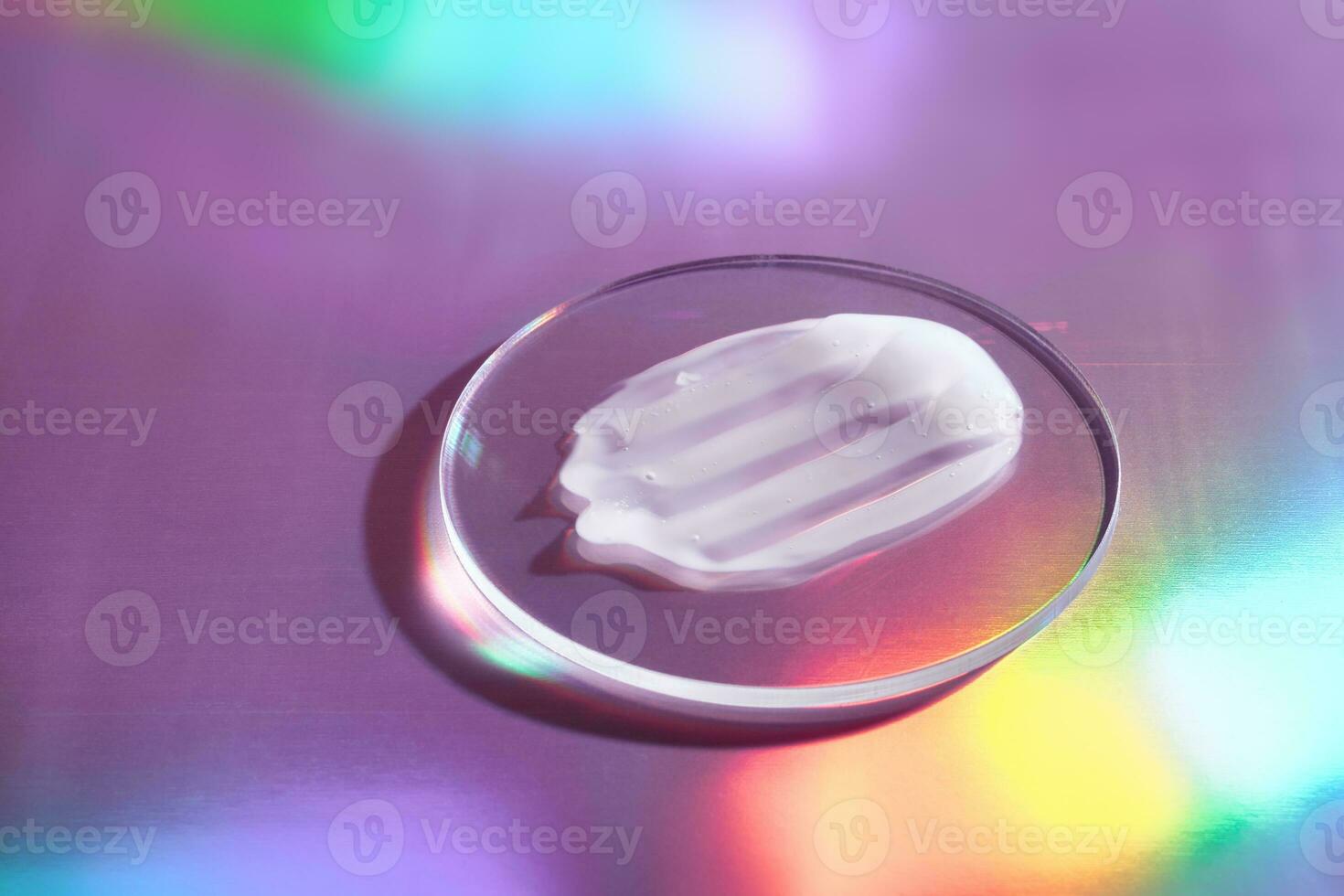 Smear of cream in petri dish on holographic background with iridescent highlights photo