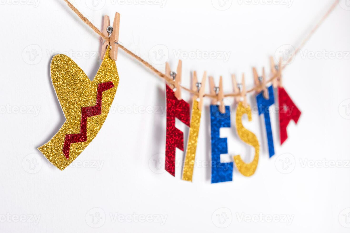 Fiesta word and sombrero made of shiny paper on pins. Fragment of festive DIY Garland of interior. Cinco de mayo celebration photo