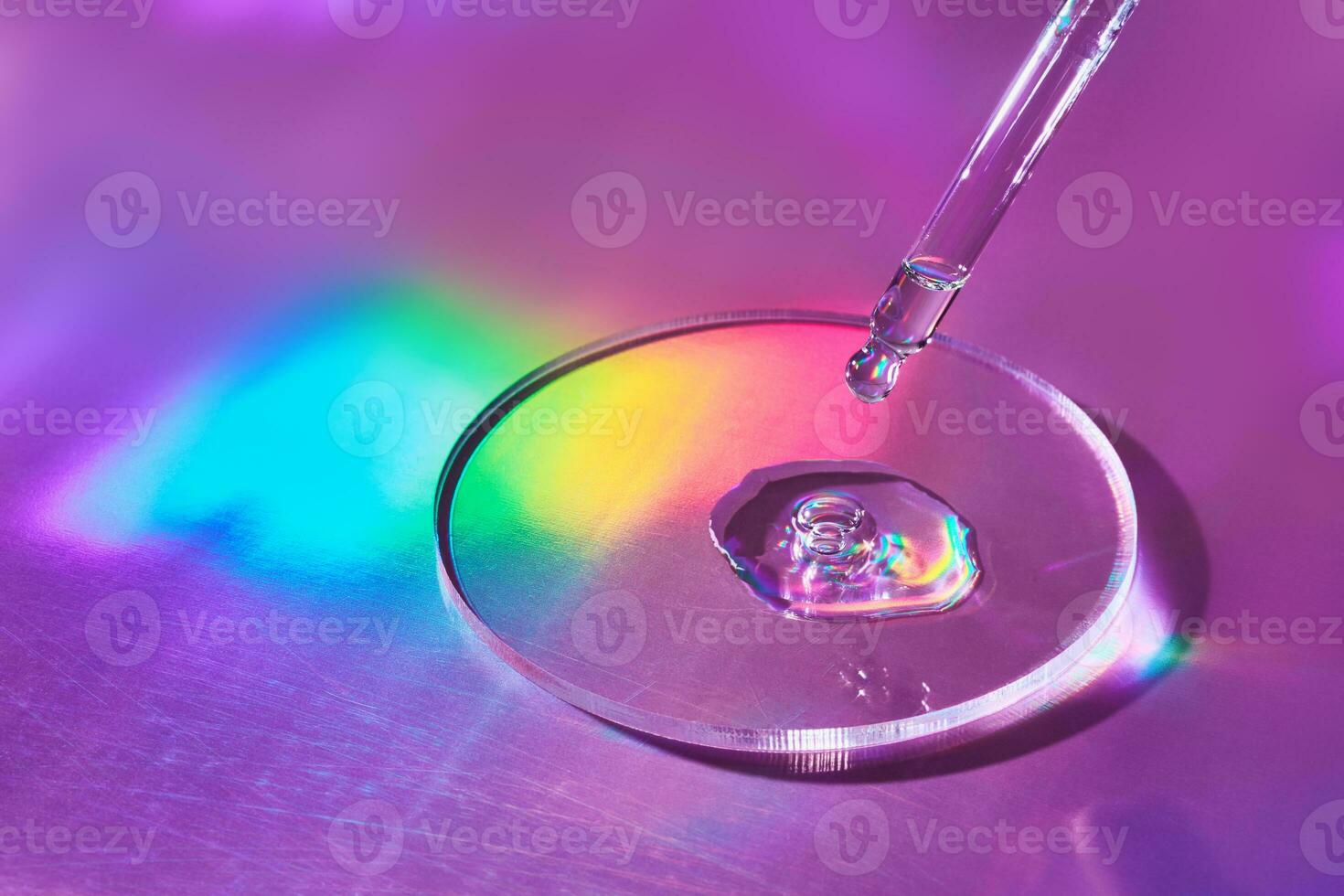 Pipette with sample of cosmetic product in petri dish on holographic background, iridescent highlights, selective focus photo