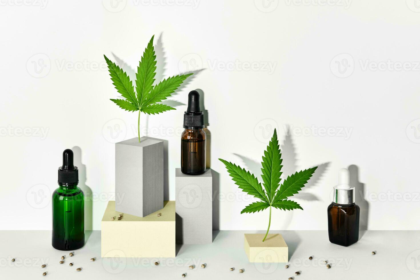 Cosmetic products with CBD oil and hemp extract. Glass bottles and hemp leaf on abstract geometric podiums with trendy shadows photo