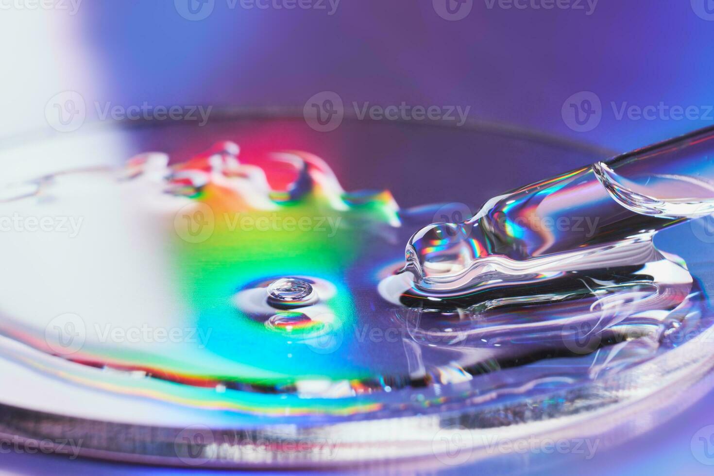 Pipette with sample of cosmetic product in petri dish on holographic background, iridescent highlights, selective focus photo