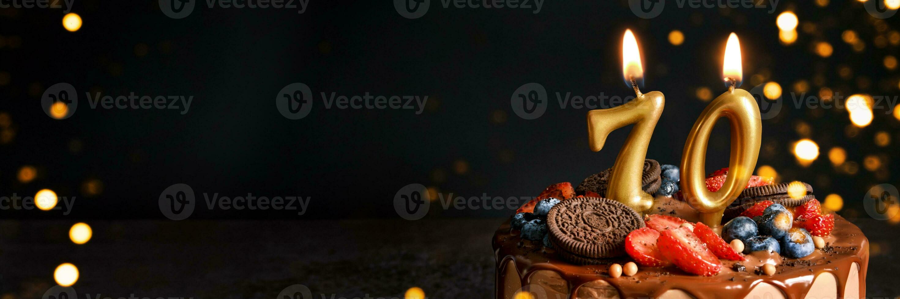 Banner with Chocolate birthday cake with berries, cookies and number sevent golden candles on black background, copy space photo