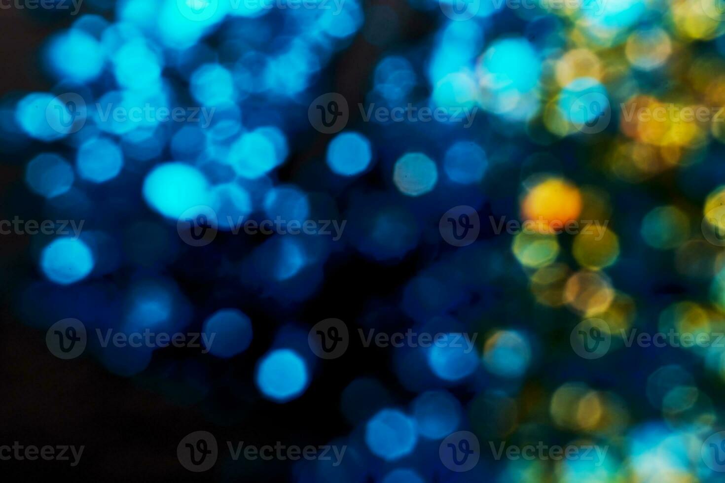 Black festive background. Abstract blue and gold bokeh lights on black. Holiday backdrop, selective focus photo
