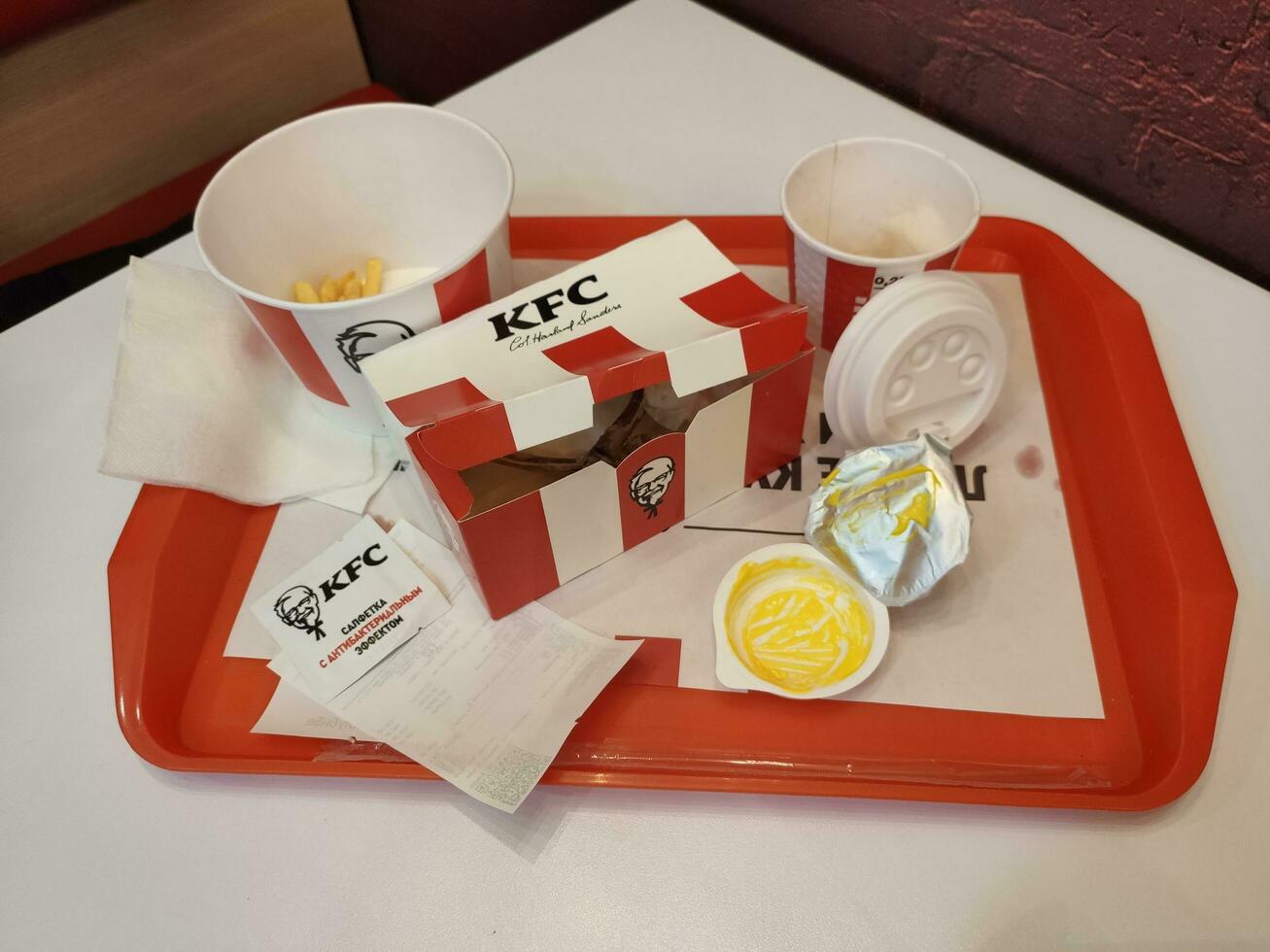 Stavropol, RUSSIA - April 2023 KFC fast food restaurant. empty boxes of fast food lie on a tray on the table photo