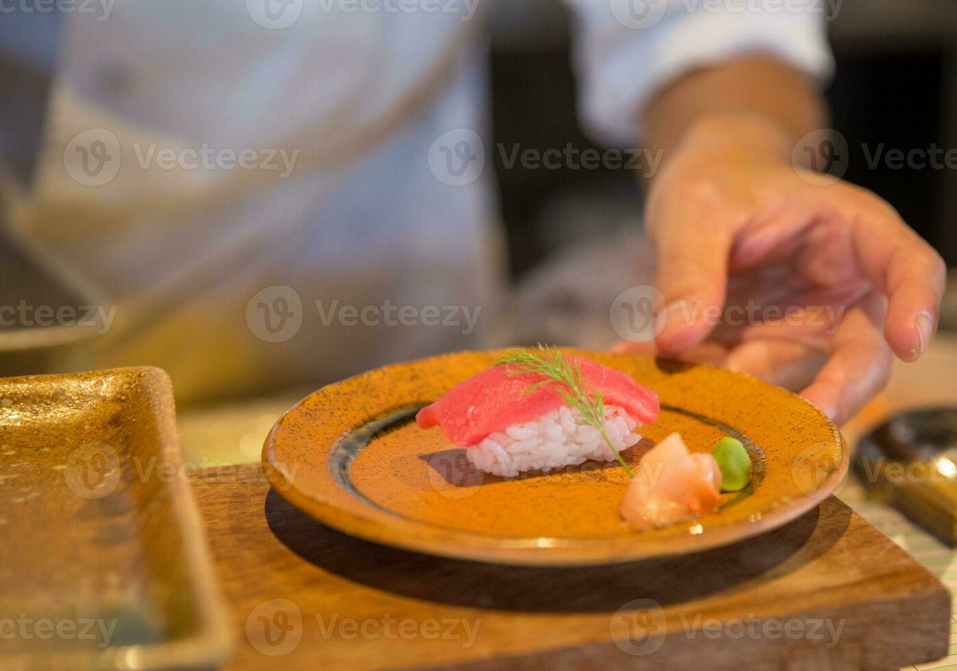 Japanese chef serving sushi photo