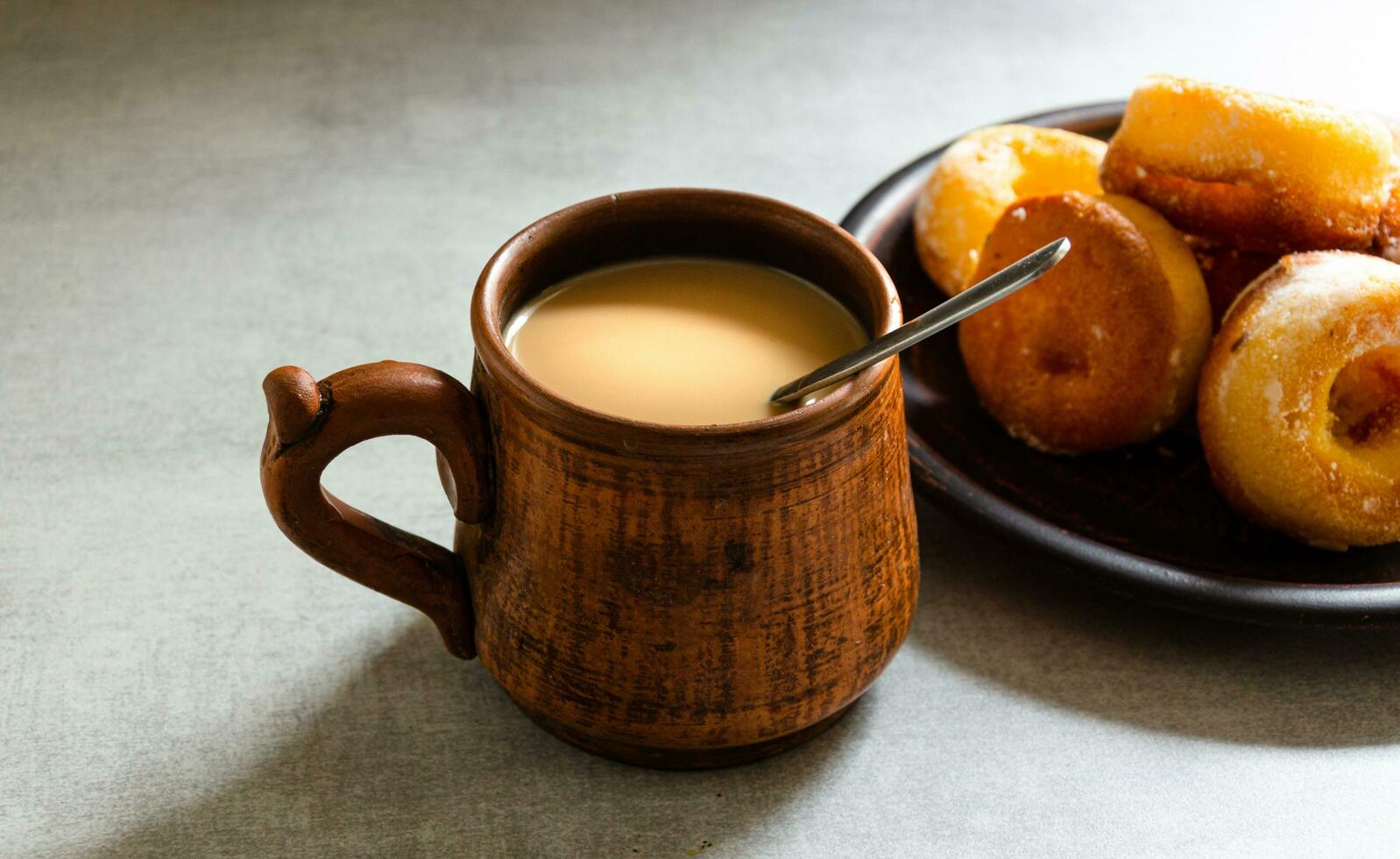 The most delicious homemade donuts and coffee with milk in a folk mug. Home cooking. photo
