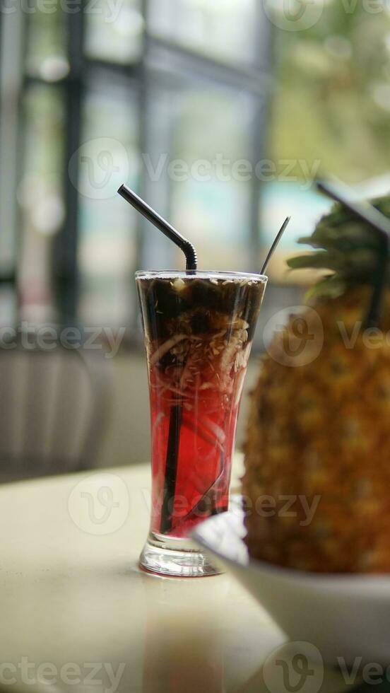 grated cucumber ice with red syrup in a long glass photo