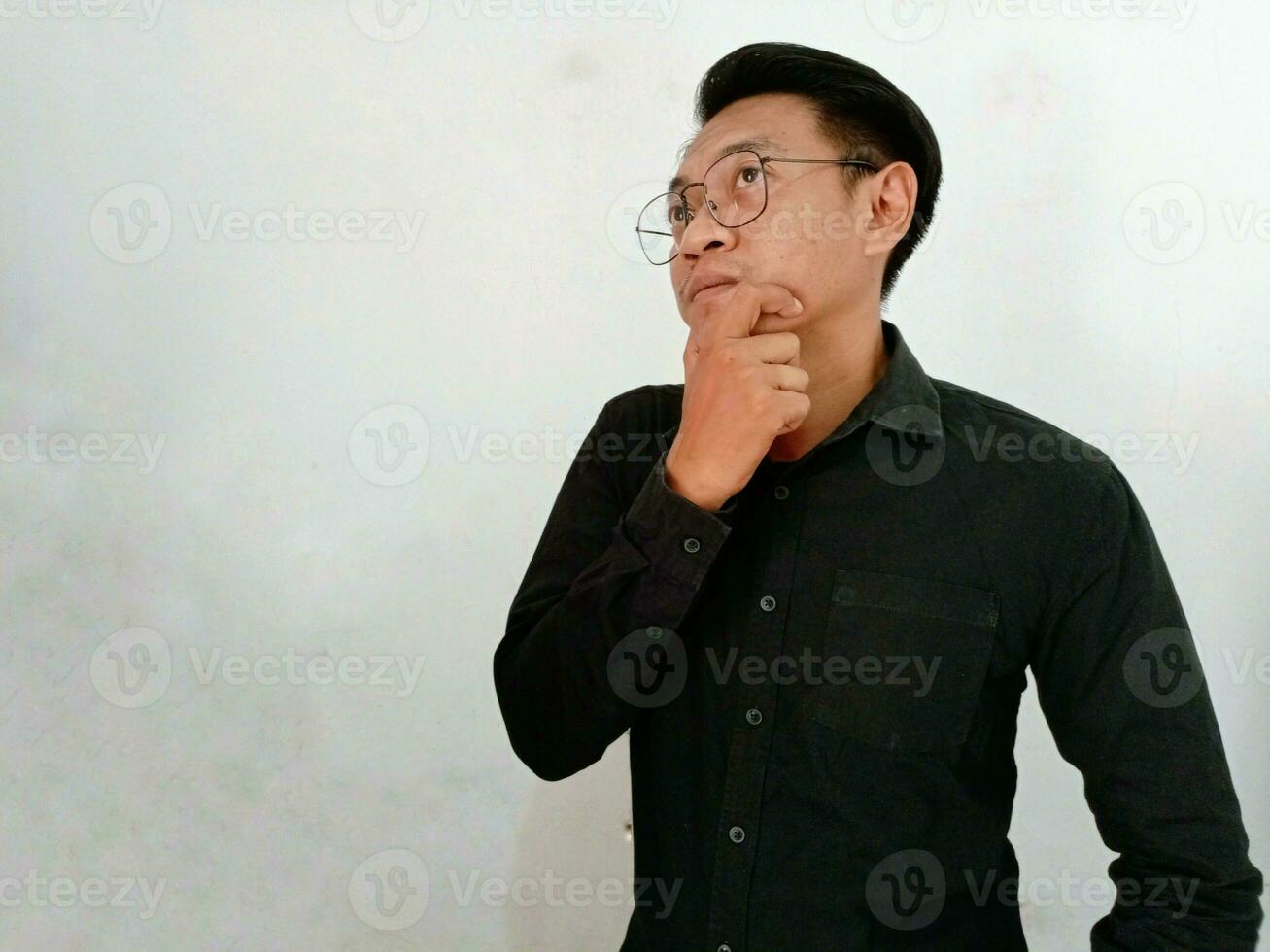 Young man wearing casual clothes thinking concentrated about doubt with finger on chin and looking up wondering photo