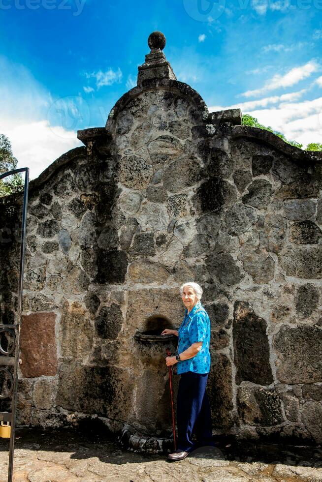 Senior woman at the beautiful historical church La Ermita built in the sixteenth century in the town of Mariquita in Colombia photo