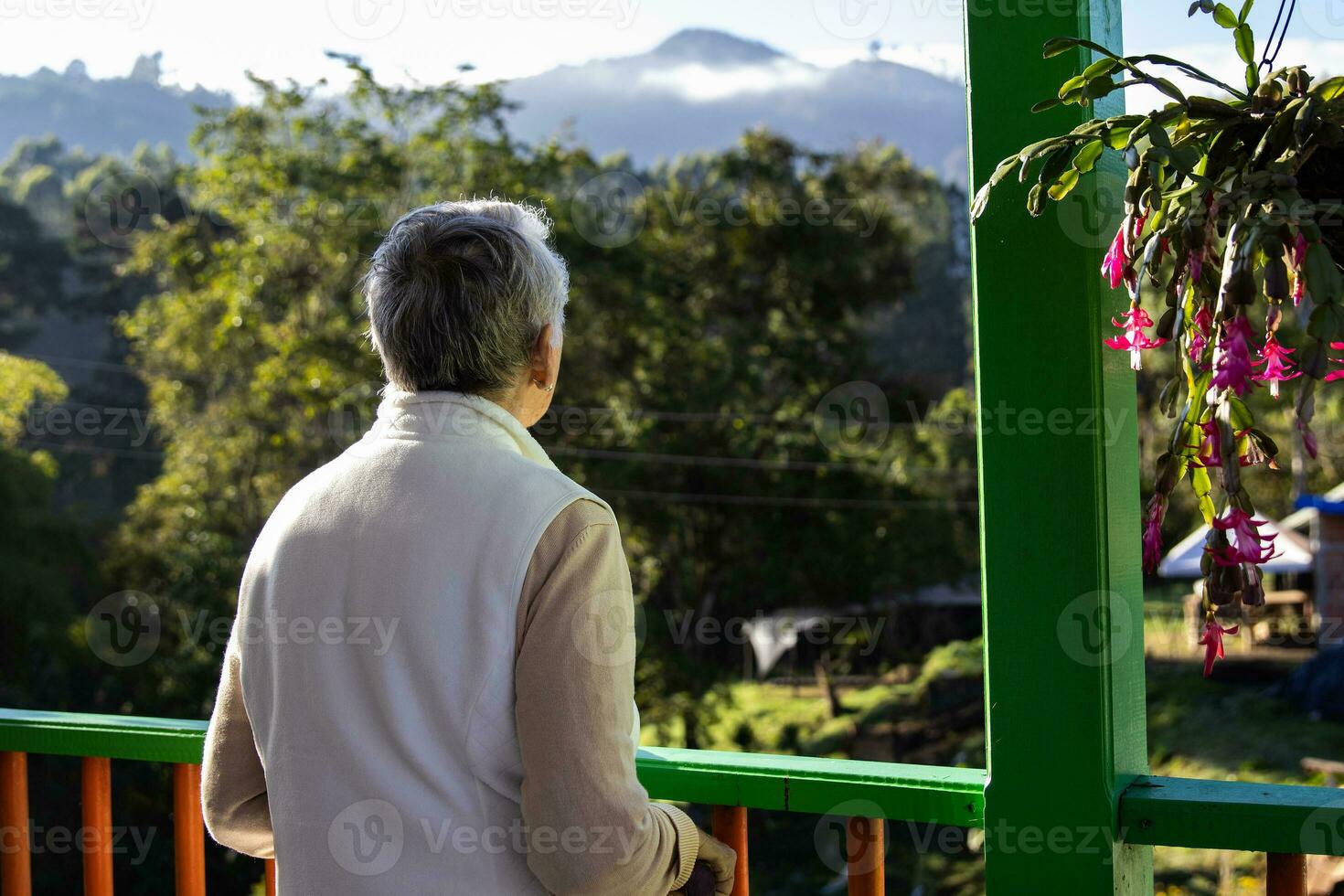 Senior woman at a traditional colorful balcony in the beautiful colonial town of Salento in the region of Quindio in Colombia photo