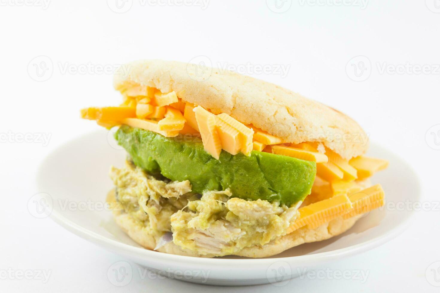 Arepas filled with shredded chicken and avocado served in a black ceramic dish on white background photo