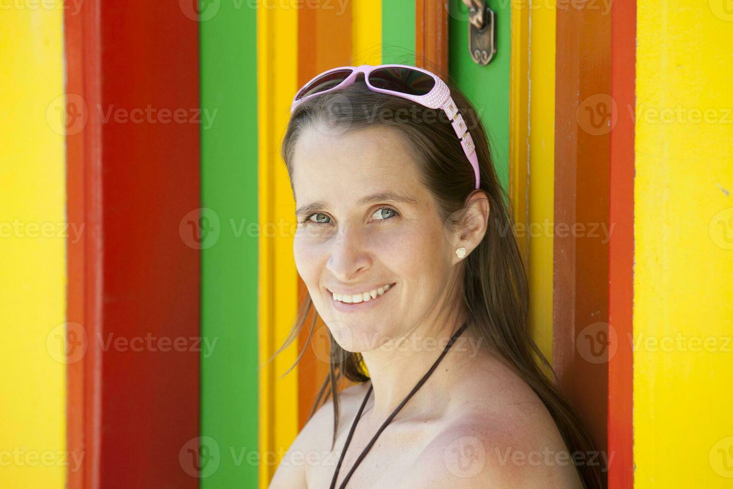 Young tourist woman next to one of the colorful doors of the Guatape town in the region of Antioquia in Colombia photo