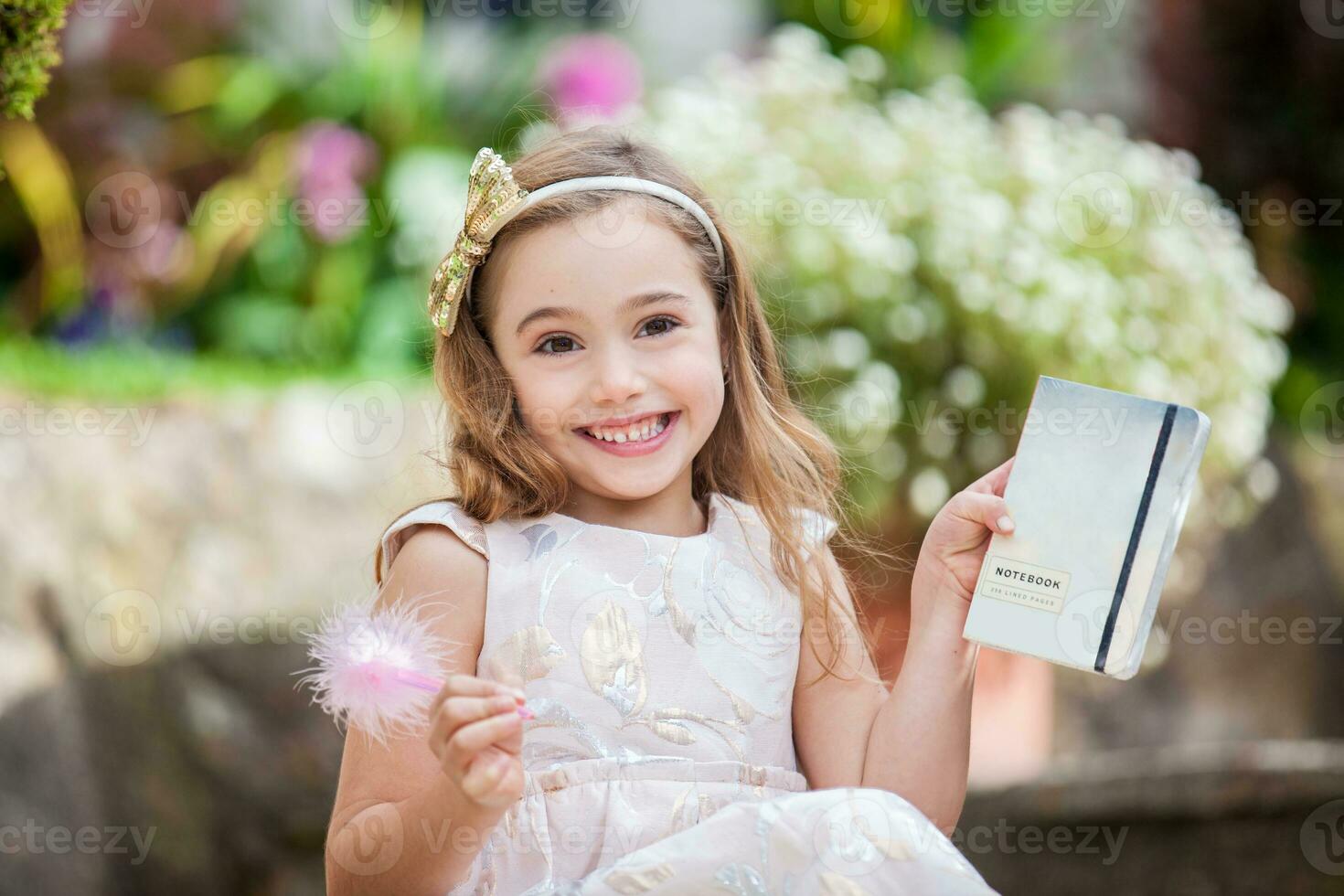 Little blonde girl writing outdoors photo