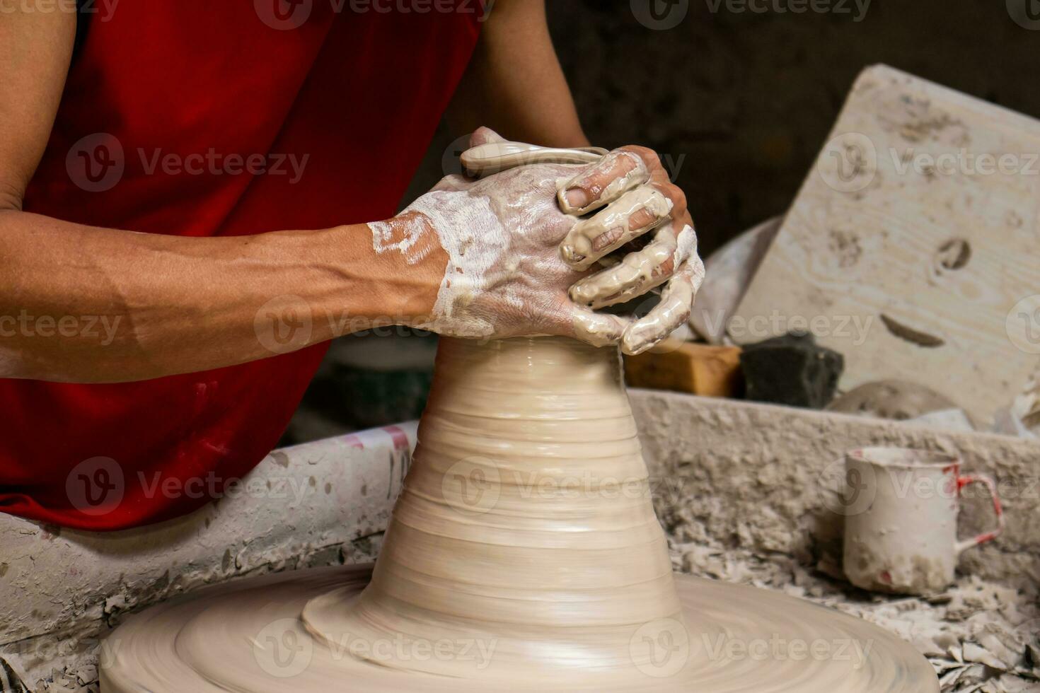Man making ceramic articles on the potters wheel in a traditional factory in the city of Raquira located in the department of Cundinamarca in Colombia photo