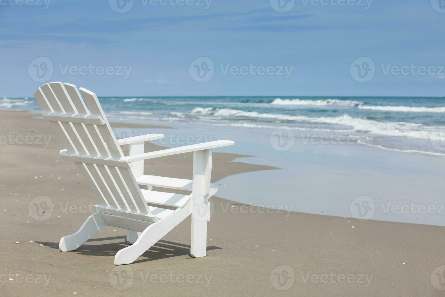 vacío blanco de madera silla a un paradisíaco playa en el zona tropical en un hermosa soleado día foto