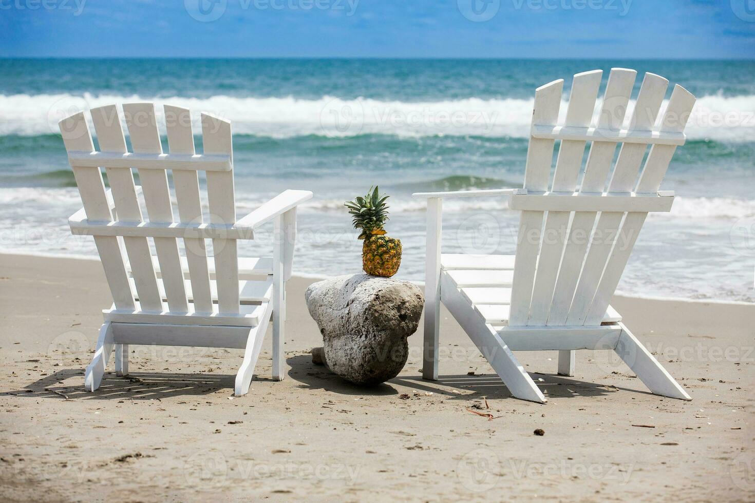 Empty white wooden chairs at a paradisiac beach on the tropics in a beautiful sunny day photo